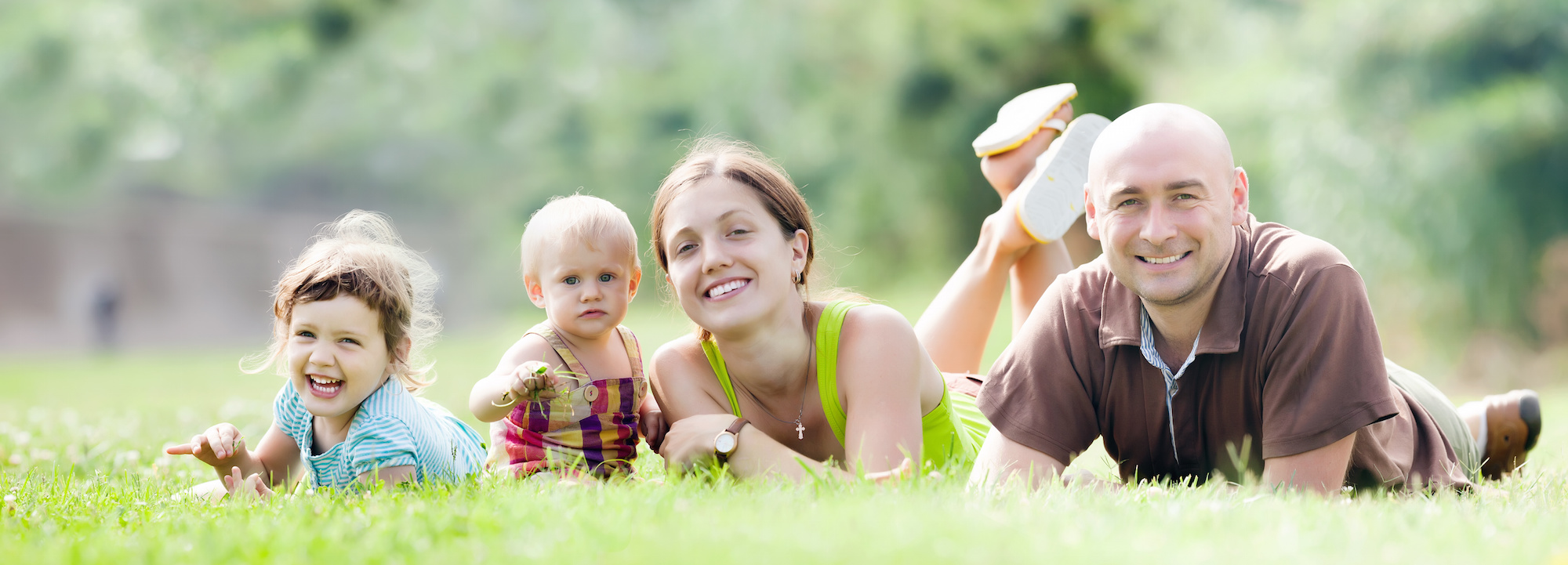 Happy family of four in summer park