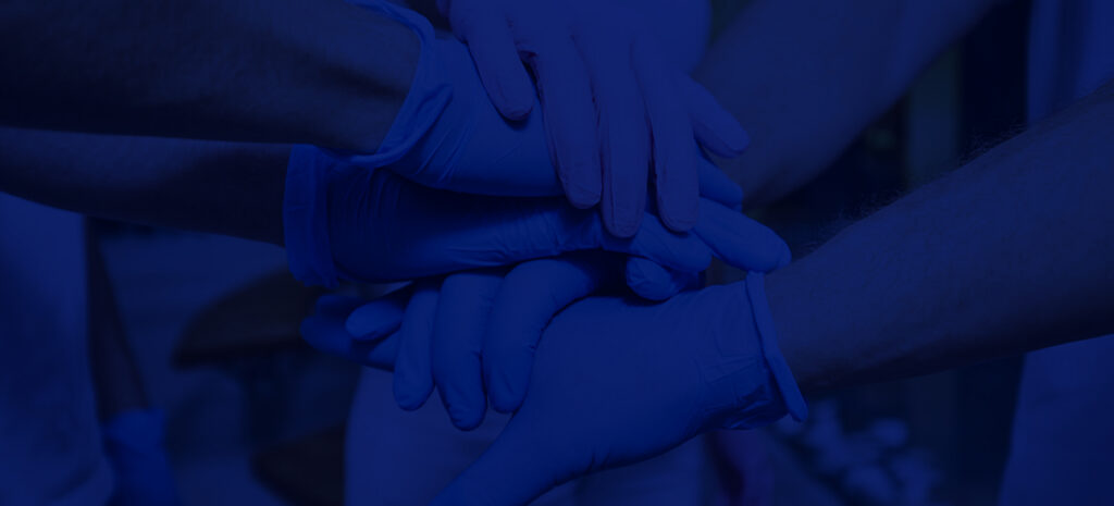 Group Shot Of Medical Professionals Holding Hands As A Team