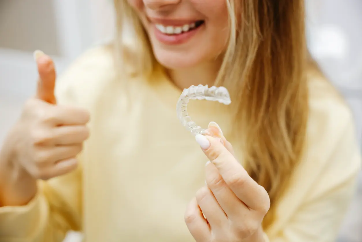 Woman holding clear aligners